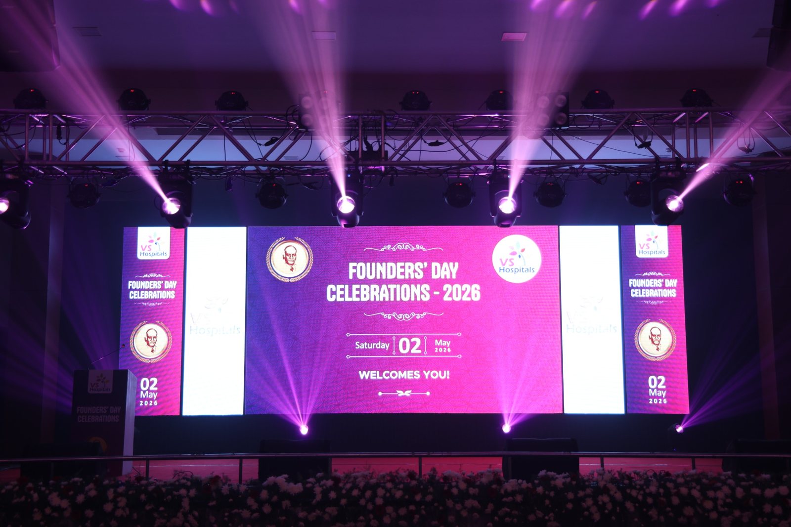 Founders Day celebration with large LED screens and stage lighting